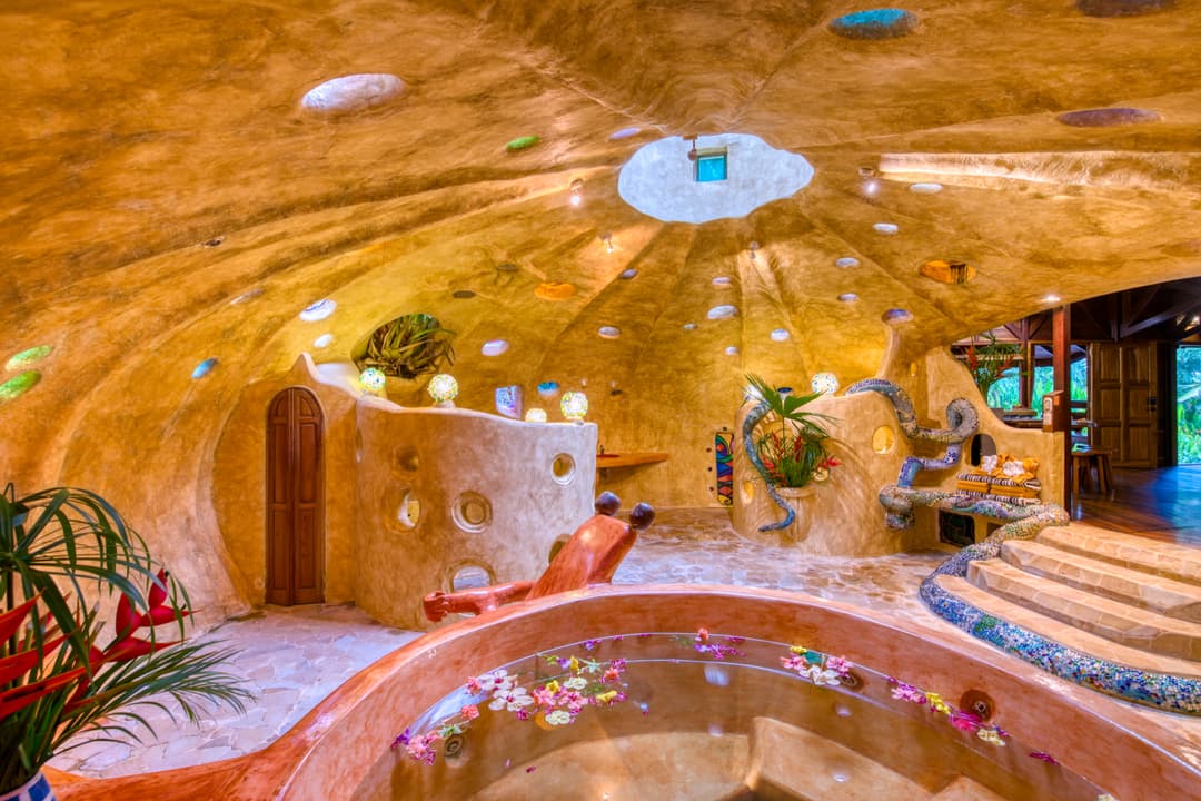 Inside the mosaic bathroom dome — warm-amber plaster ceiling studded with coloured-glass insets, sunken basin pool